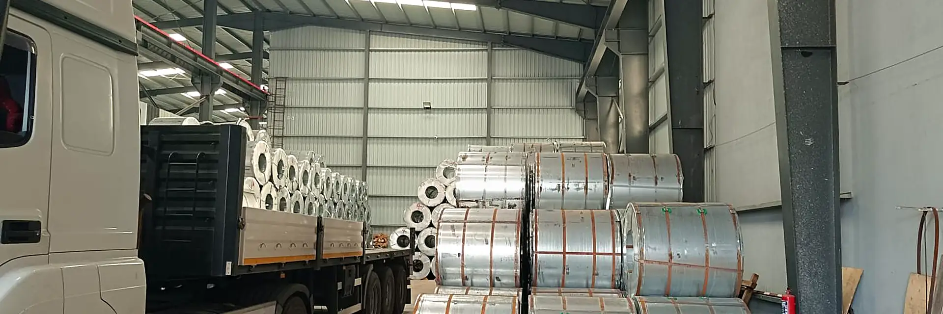 A trailer loaded with steel coils inside the warehouse