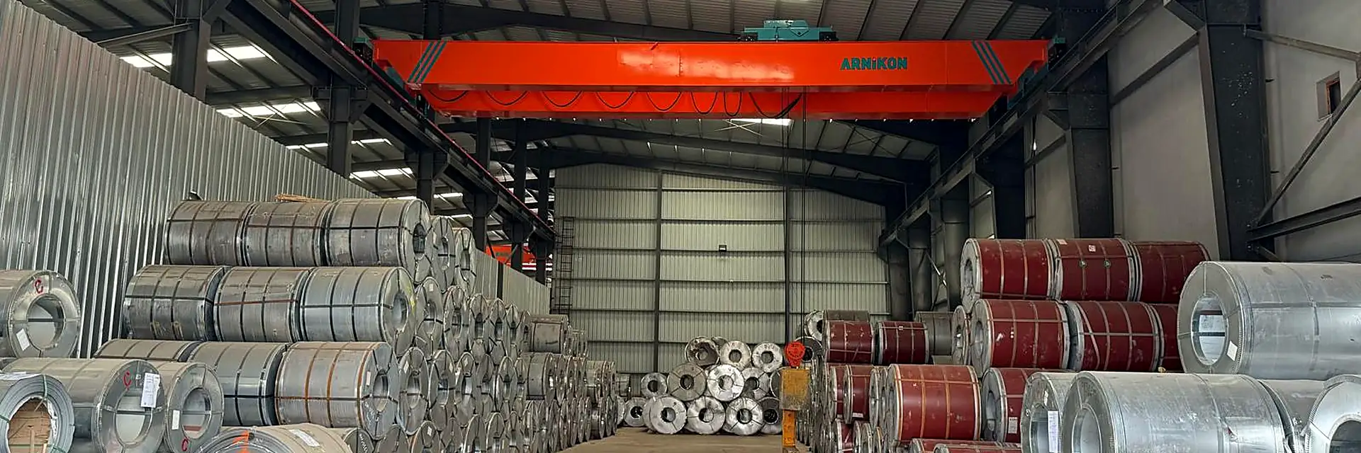 Kral Antrepo's covered warehouse aisle, with galvanised and pre-painted steel coils stacked on both sides