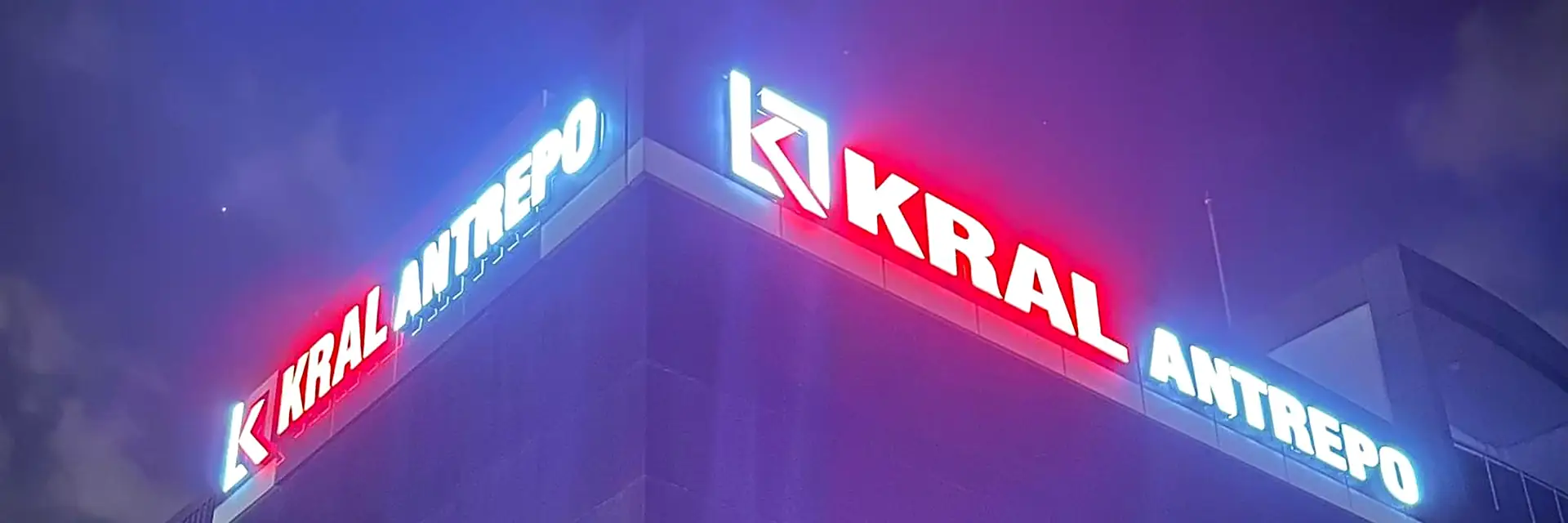 Kral Antrepo idari binasının gece görünümü; ışıklı cephe tabelası