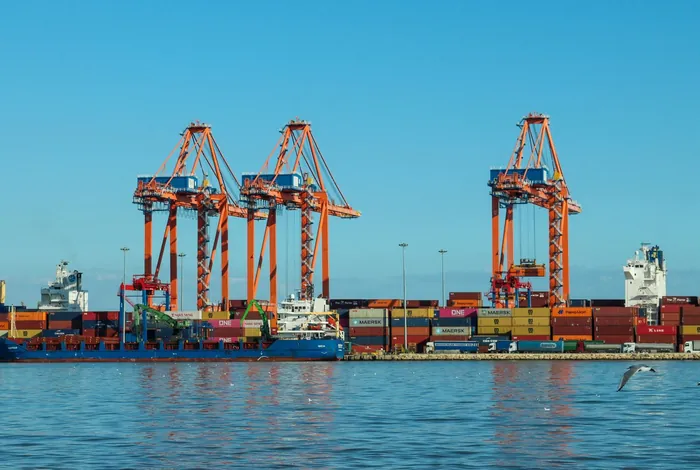 Orange quay cranes and a berthed container ship at a container port