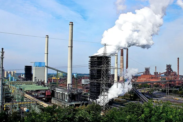 An integrated steelworks with blast furnaces and stacks releasing steam